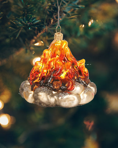 Stemningsfuld julekugle i glas, der forestiller et lejrbål